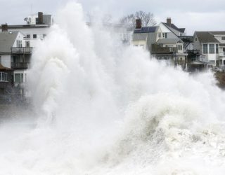 A large wave crashes into a seawall in Winthrop, Mass., Saturday, March 3, 2018, a day after a nor'easter pounded the Atlantic coast. Officials in eastern Massachusetts, where dozens of people were rescued from high waters overnight, warned of another round of flooding during high tides expected at midday. (AP Photo/Michael Dwyer)