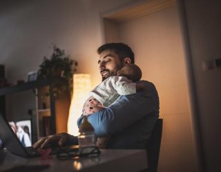 Young father working at home with his baby  girl